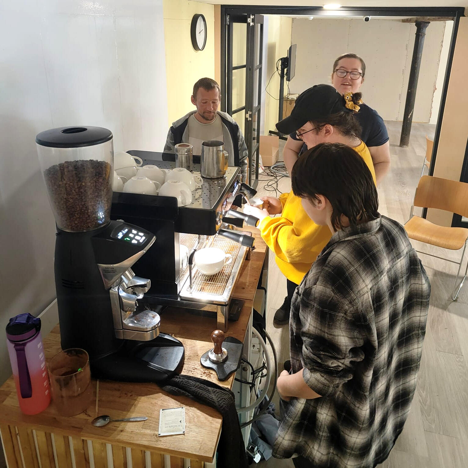 Students learning barista skills on a mobile coffee training bar